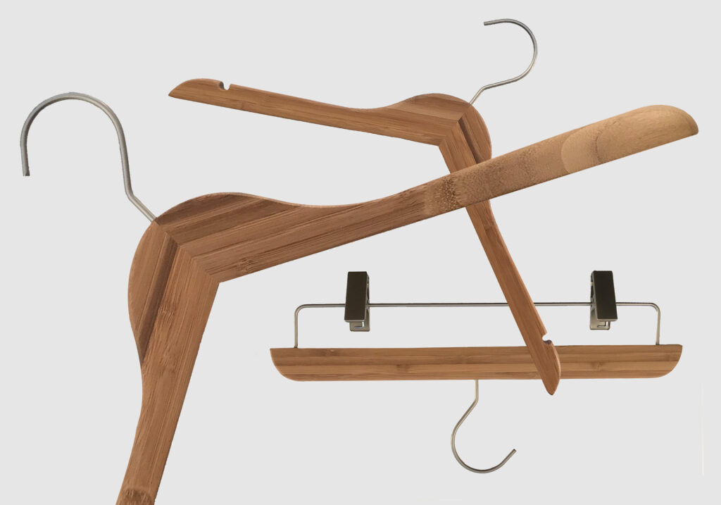 Hangers of London A set of three wooden hangers is displayed against a plain white background. One hanger is for pants, with clips at the ends, another is a standard clothes hanger, and the third one has an anti-slip notched design for securing garments with straps.