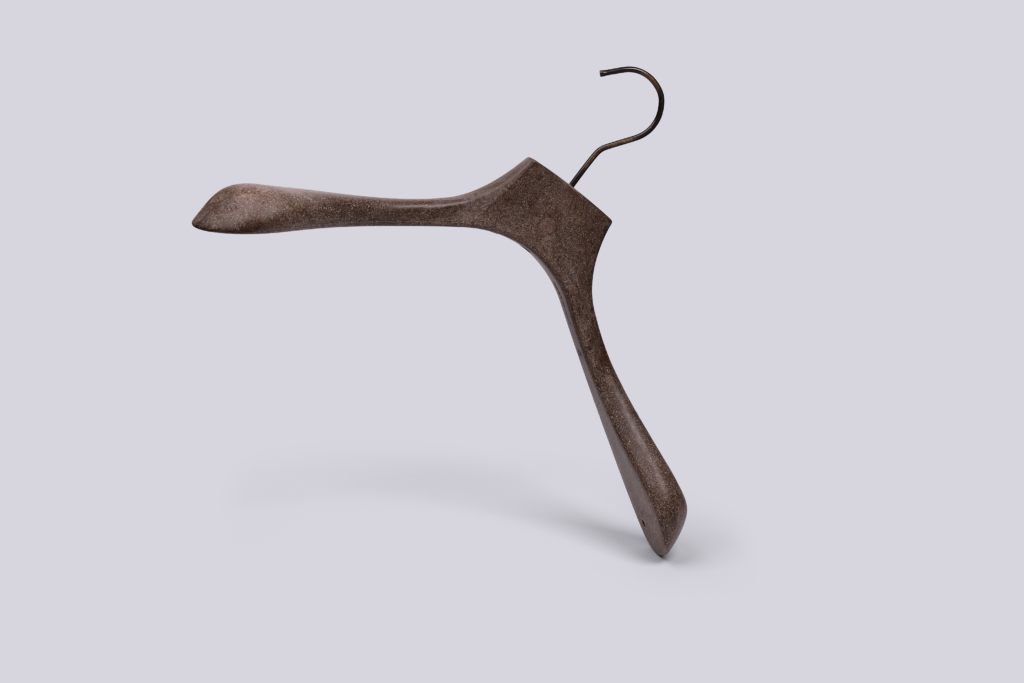 Hangers of London A brown wooden clothes hanger with an unusually twisted and asymmetrical shape, standing upright on a light grey background.